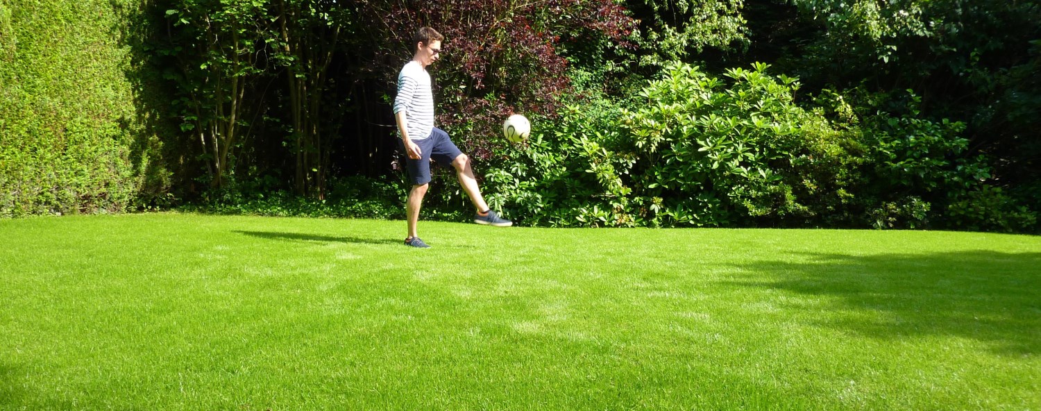 Enfant jouant sur une pelouse dans un jardin